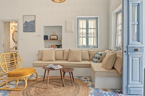 A living room with a sofa, a chair, a small table, and a decorative wall piece.
