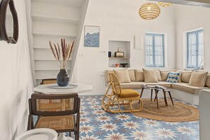 A modern living room with a sofa, a dining table, and a chair.