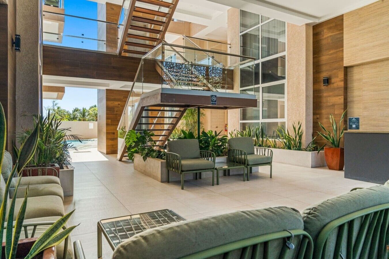 Un espace intérieur moderne comprenant un escalier, des sièges et des plantes en pot.