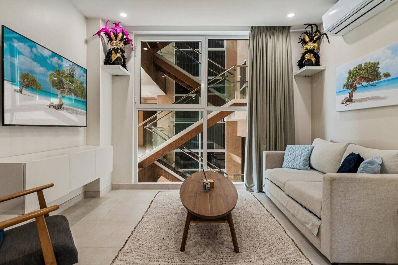 Un salon moderne avec un canapé, une table basse et un escalier menant à l’étage supérieur.
