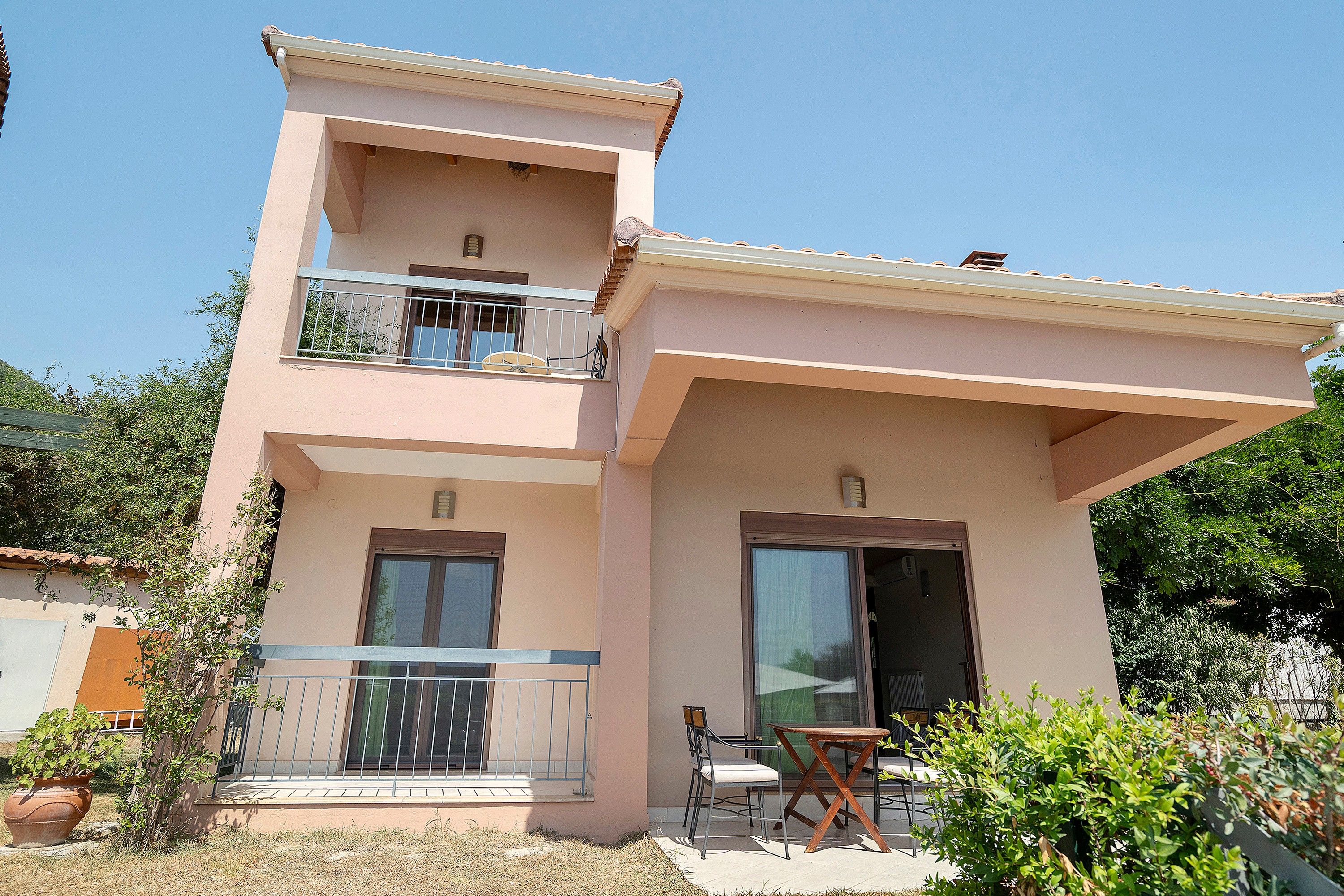 A two-story building with a balcony, a door, and a window.