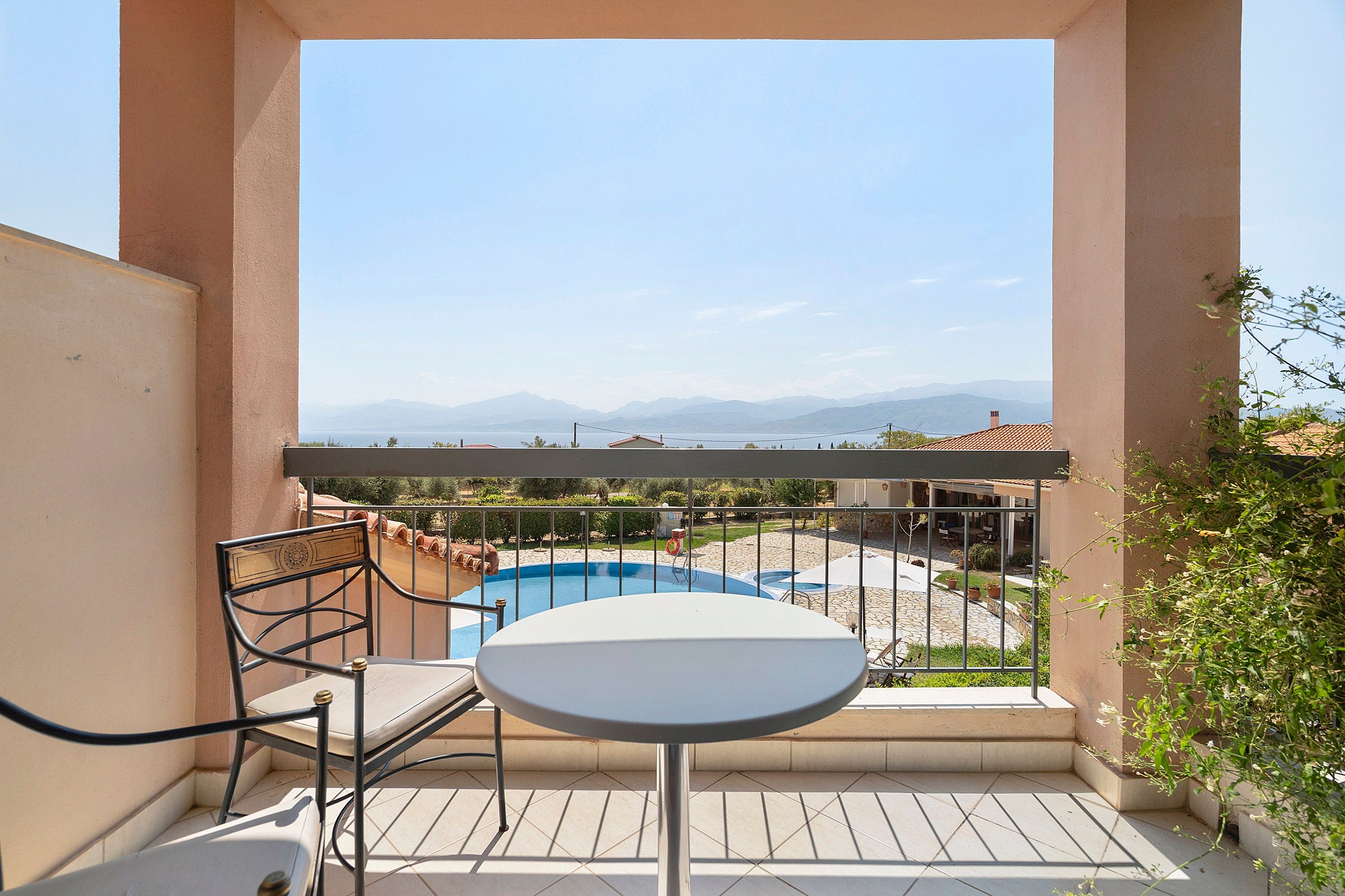 Un balcon avec vue sur une piscine et des montagnes.