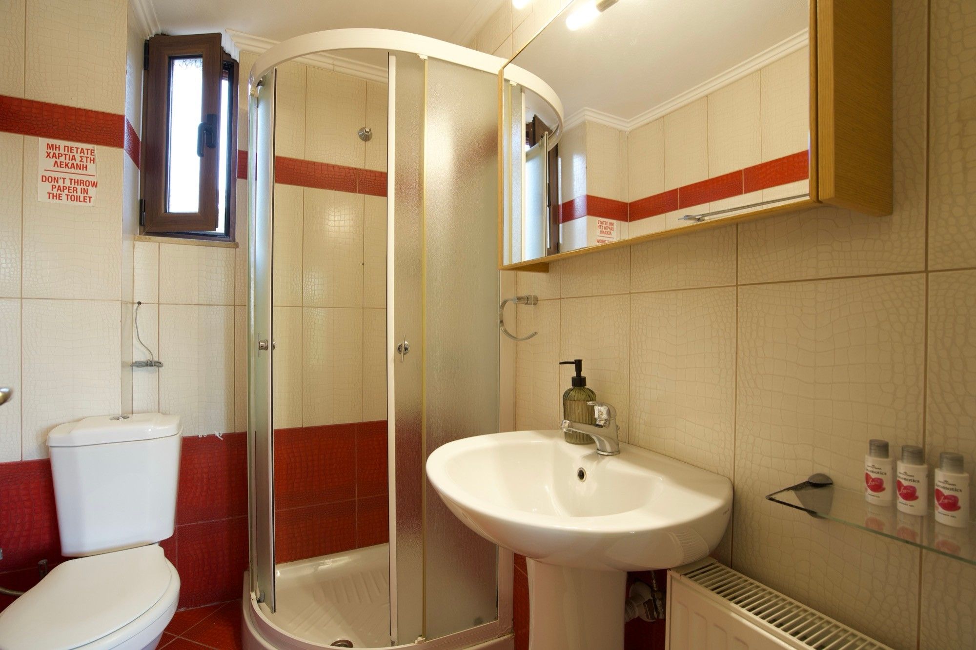 Ein Badezimmer mit Toilette, einer Duschkabine und einem Waschbecken.