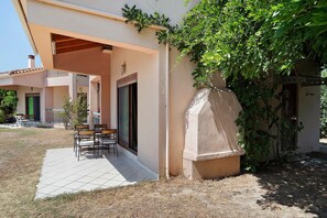 A building with a covered patio area, outdoor seating, and a stone structure. - Villa 'Ilektra' in Marathiás (Marathiás)
