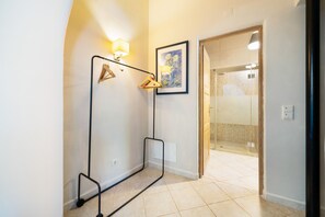 A hallway with a coat rack, a framed painting, and a shower area visible through an open door. - Room 'The Courtyard' with Shared Pool, Shared Garden and Wi-Fi (Almancil)