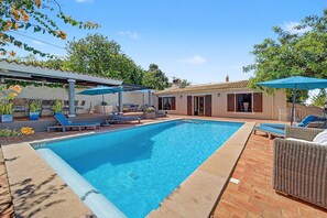 A rectangular swimming pool with a tiled edge, surrounded by lounge chairs and umbrellas. - Room 'The Courtyard' with Shared Pool, Shared Garden and Wi-Fi (Almancil)