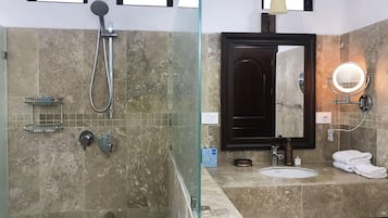 Une salle de bain équipée d’une douche, d’un lavabo, d’un miroir et d’un porte-serviettes.