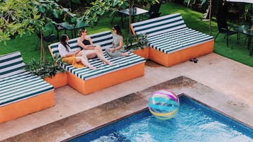 A poolside area with lounge chairs and a pool.