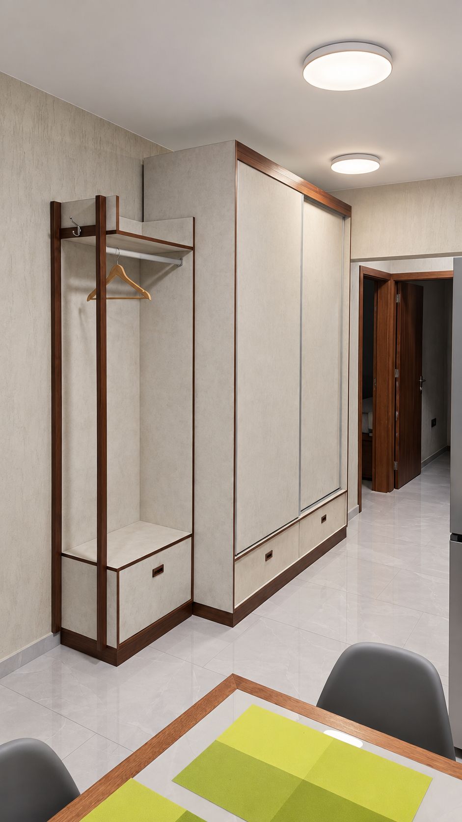 Een kamer met een kast, een tafel met stoelen en een deur naar een andere kamer.