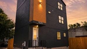A modern two-story building with a flat roof, a visible address number, and a set of stairs leading to the entrance. - Rooftop Rodeo • Hot Tub, FirePit • 3mi to Broadway (Nashville)
