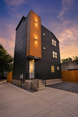 A modern two-story building with a flat roof, a visible address number, and a set of stairs leading to the entrance. - Rooftop Rodeo • Hot Tub, FirePit • 3mi to Broadway (Nashville)