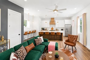 A modern kitchen with white cabinets, a central island, and bar stools.