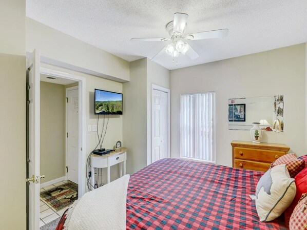 A bedroom with a bed, a desk, a television, and a ceiling fan. - One BR City View | King Bedroom| Sleeps 4 | Free Dollywood Tickets (Pigeon Forge)