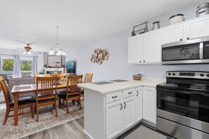 A modern kitchen with white cabinetry, a built-in microwave, and a stainless steel oven. - Whispering Pines 634 | 4BR Luxury Condo in the Heart of Pigeon Forge Sleeps 10 (Pigeon Forge)