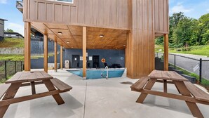 Un área de piscina con bancos de madera y un trampolín.