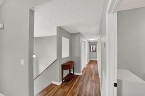 A hallway with wooden flooring, white walls, and a wooden bench. - Three bedroom, three bathroom| Riverfront home| Sleeps 10 (Sevierville)