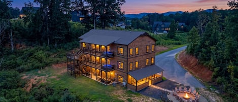 A multi-story house with a fire pit in the front yard.