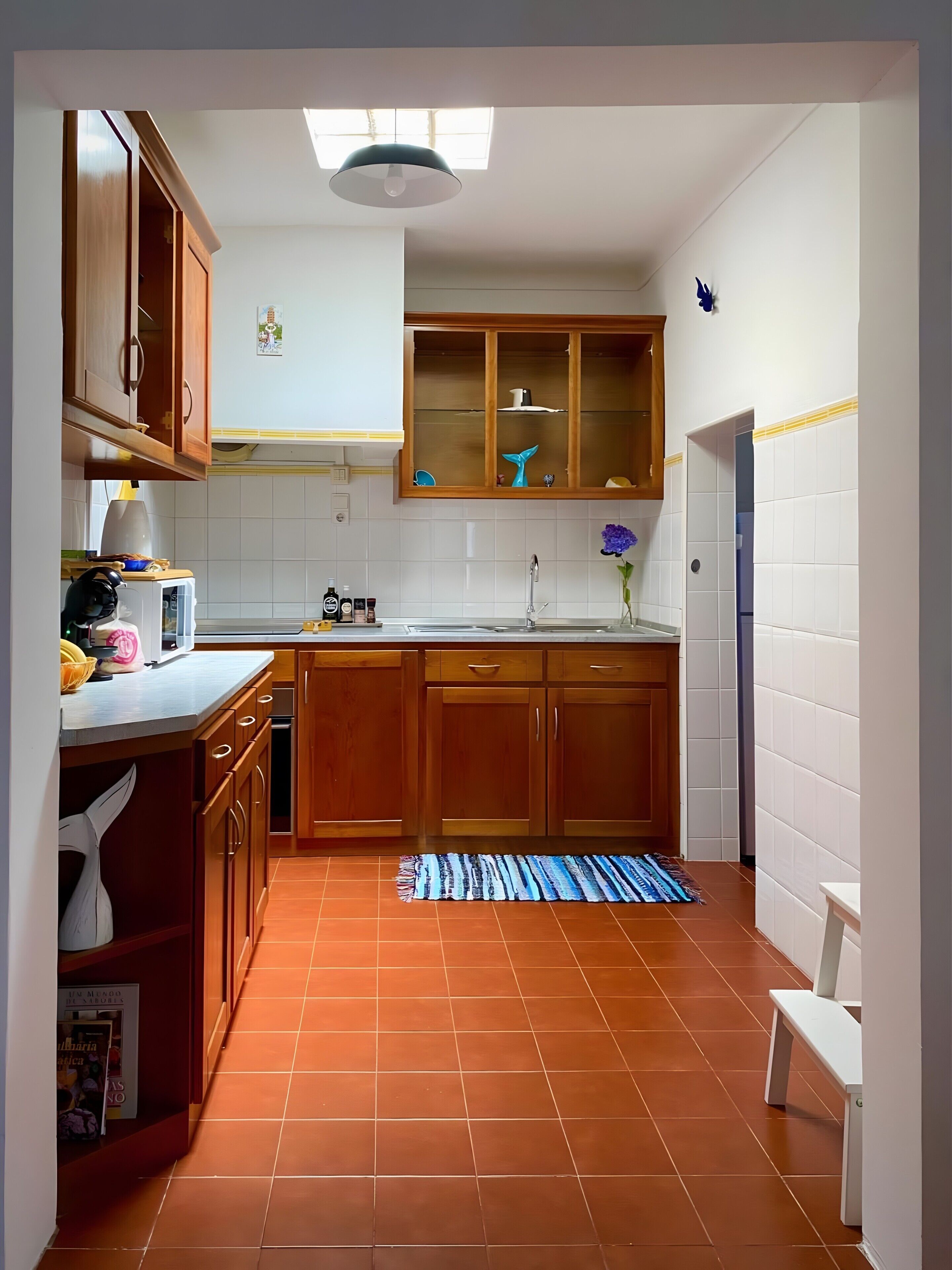 A kitchen with wooden cabinets, a tiled backsplash, and a window above the sink.