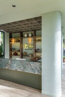 Un mostrador de recepción con encimera de mármol, estanterías con adornos y un letrero que dice 'Velto Serene'.