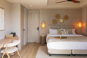 Un dormitorio con cama, mesita de noche, silla y escritorio con otra silla. Hay lámparas de pared y un ventilador de techo.