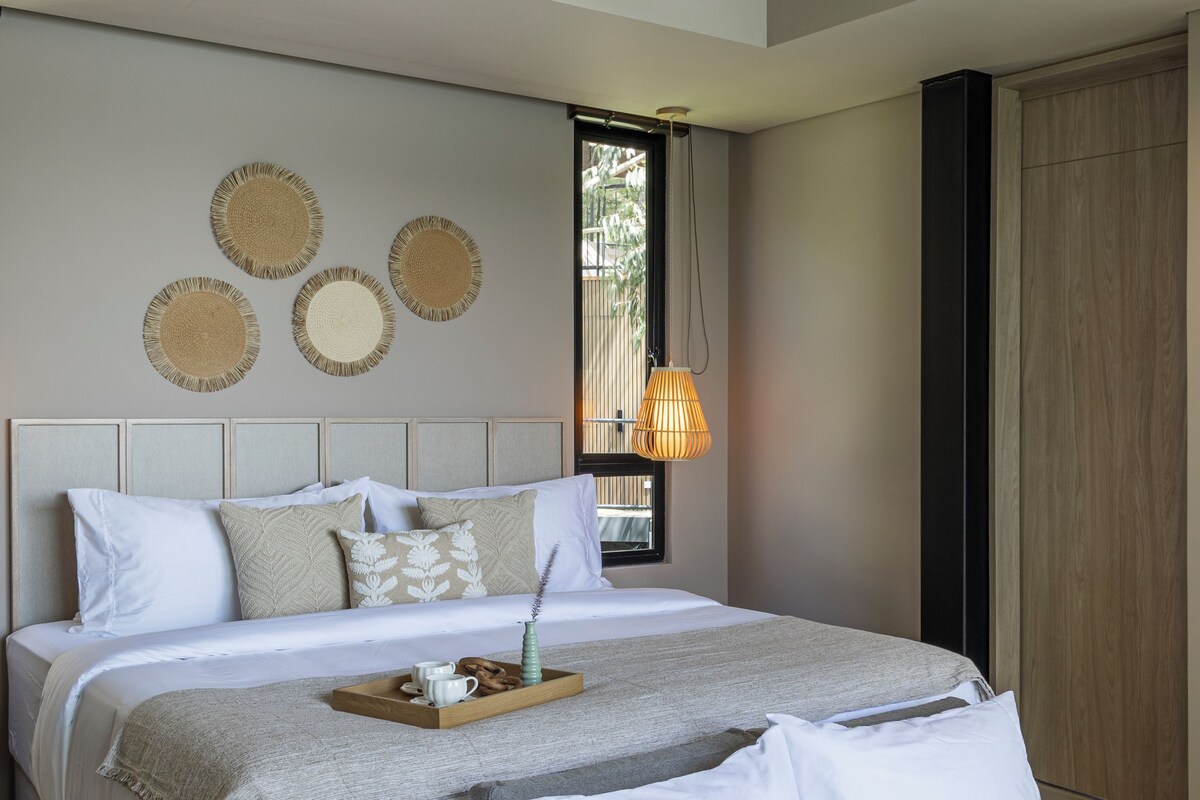 Un dormitorio moderno con una cama grande, un ventilador de techo y una ventana con vistas.