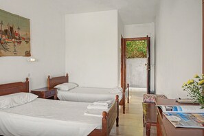 A hotel room with two single beds, a wooden desk, a chair, a small table, and a painting on the wall. - Room 'Orama 25' with Sea View, Wi-Fi and Air Conditioning (Εύβοια)