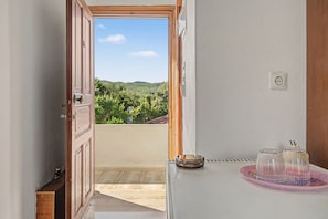 A room with a wooden door leading to a balcony with a view of greenery and hills. - Room 'Orama 33' with Sea View, Wi-Fi and Air Conditioning (Εύβοια)