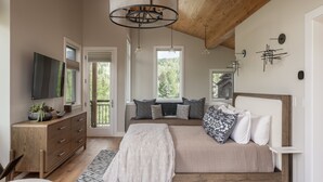 A bedroom with a bed, a dresser, a TV, and a window. - Stylish Mountain Village Getaway | Fireplace, Grill & Mountain Views (Telluride)