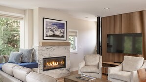 A modern living room with a fireplace, comfortable seating, and a large flat-screen TV. - Stylish Mountain Village Getaway | Fireplace, Grill & Mountain Views (Telluride)