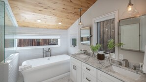A modern bathroom with a freestanding bathtub, a large mirror, and a wooden ceiling. - Stylish Mountain Village Getaway | Fireplace, Grill & Mountain Views (Telluride)