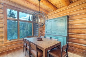 A wooden interior with a dining table, chairs, a chandelier, and a cabinet. - Luxury Mountain Village Retreat | Panoramic Mountain Views | Private Hot Tub | Sleeps 9 (Telluride)