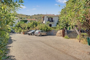 A residential area with a paved driveway, parked cars, and houses with balconies. - Room 'Orama  17' with Sea View, Wi-Fi and Air Conditioning (Εύβοια)