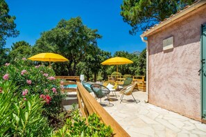 Ein Sitzbereich im Freien mit gelben Sonnenschirmen, einem Pool und einer Steinterrasse.