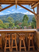 Un bar exterior de madera con vistas a un paisaje montañoso.