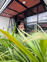 Un interior moderno con un amplio ventanal, techo de madera y vistas al exterior.