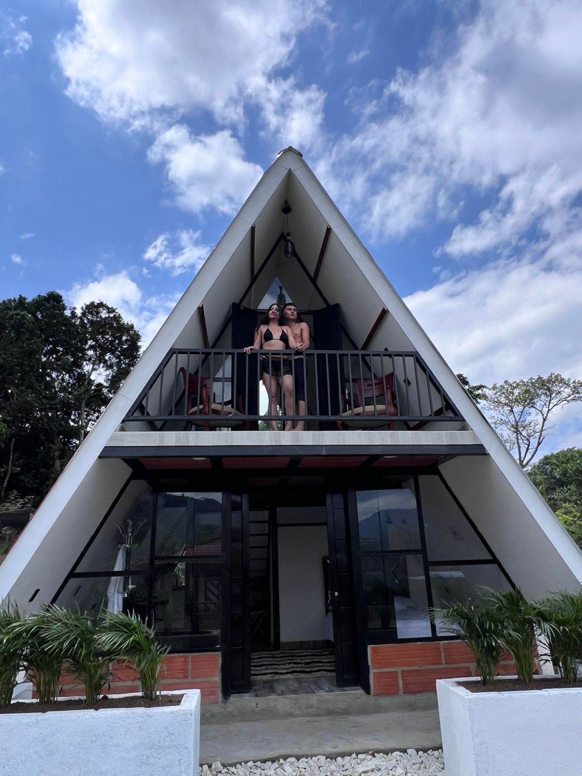Un edificio moderno con techo triangular y balcón.