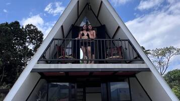 Un edificio moderno con techo triangular y balcón.