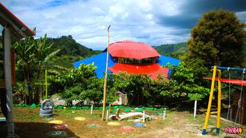 A playground with colorful play equipment and a red-roofed structure.