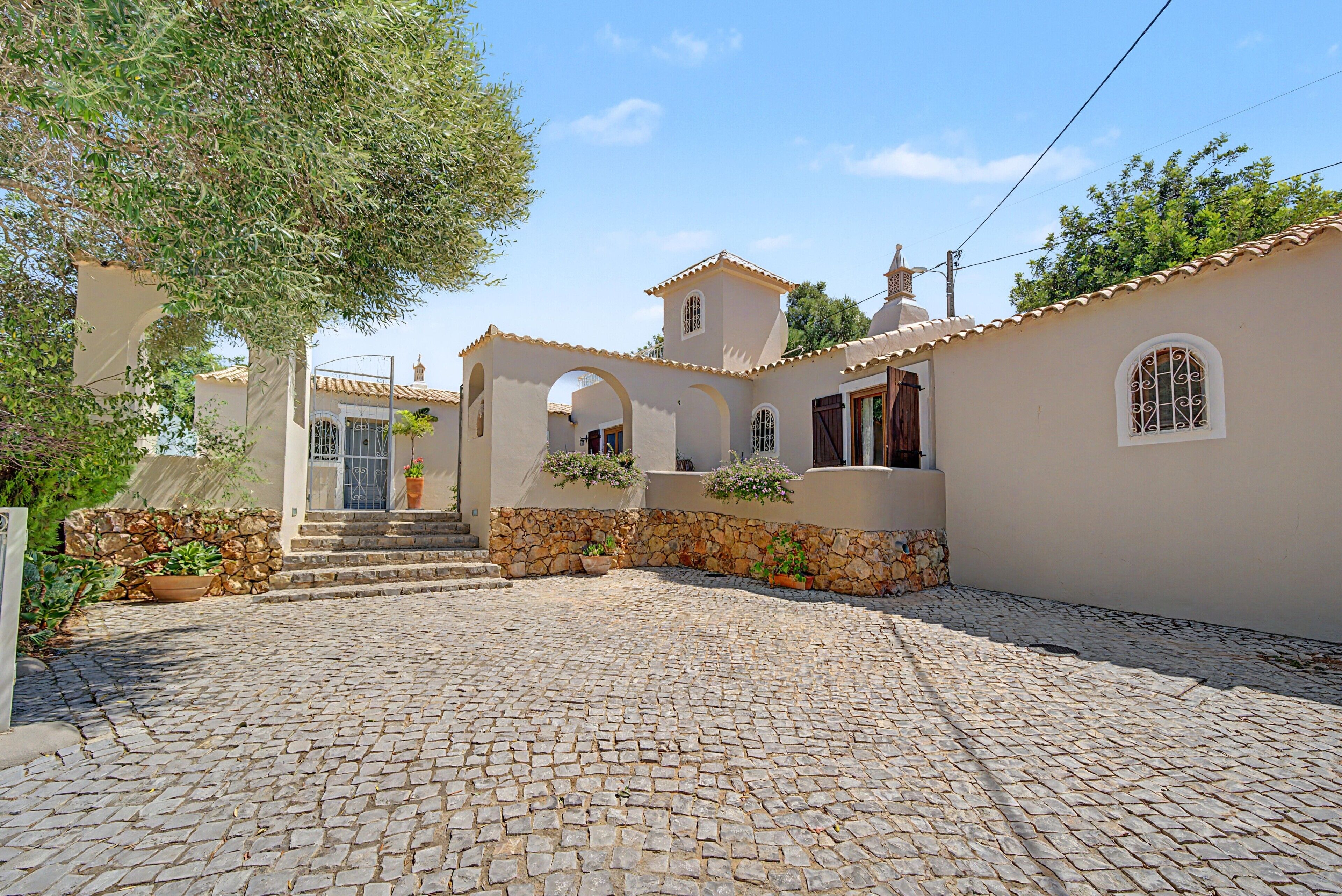 Un edificio in stile mediterraneo tradizionale con un cortile in pietra, pareti di pietra e portali ad arco.