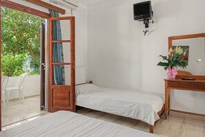 A room with a bed, a desk with a mirror, a television mounted on the wall, and a window with curtains. - Room 'Orama 24' with Sea View, Wi-Fi and Air Conditioning (Εύβοια)
