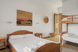Ein Schlafzimmer mit einem hölzernen Bett, einem Etagenbett, einem Nachttisch, einer Wandleuchte und einem Gemälde.