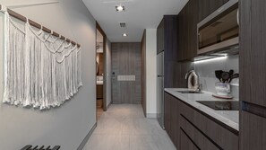 Een moderne keuken met een inbouwoven, een spoelbak en een aanrecht met keukengerei.