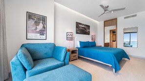 Ein Hotelzimmer mit Bett, Sofa, Deckenventilator und Bildern an den Wänden.