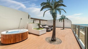 A rooftop terrace with a hot tub, seating area, and palm trees. - One 1702 Penthouse: Star Wars Luxury Penthouse (Puerto Peñasco)