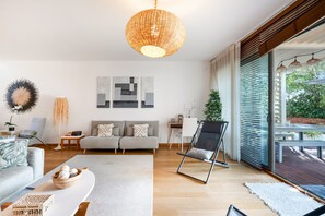 Een moderne woonkamer met een bank, een salontafel en een eethoek met een tafel en stoelen.