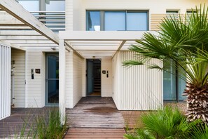 A modern building with a covered walkway leading to a door marked B9. - Holiday Home 'Tróia - Amazing Places' with Wi-Fi and Air Conditioning (Grândola)