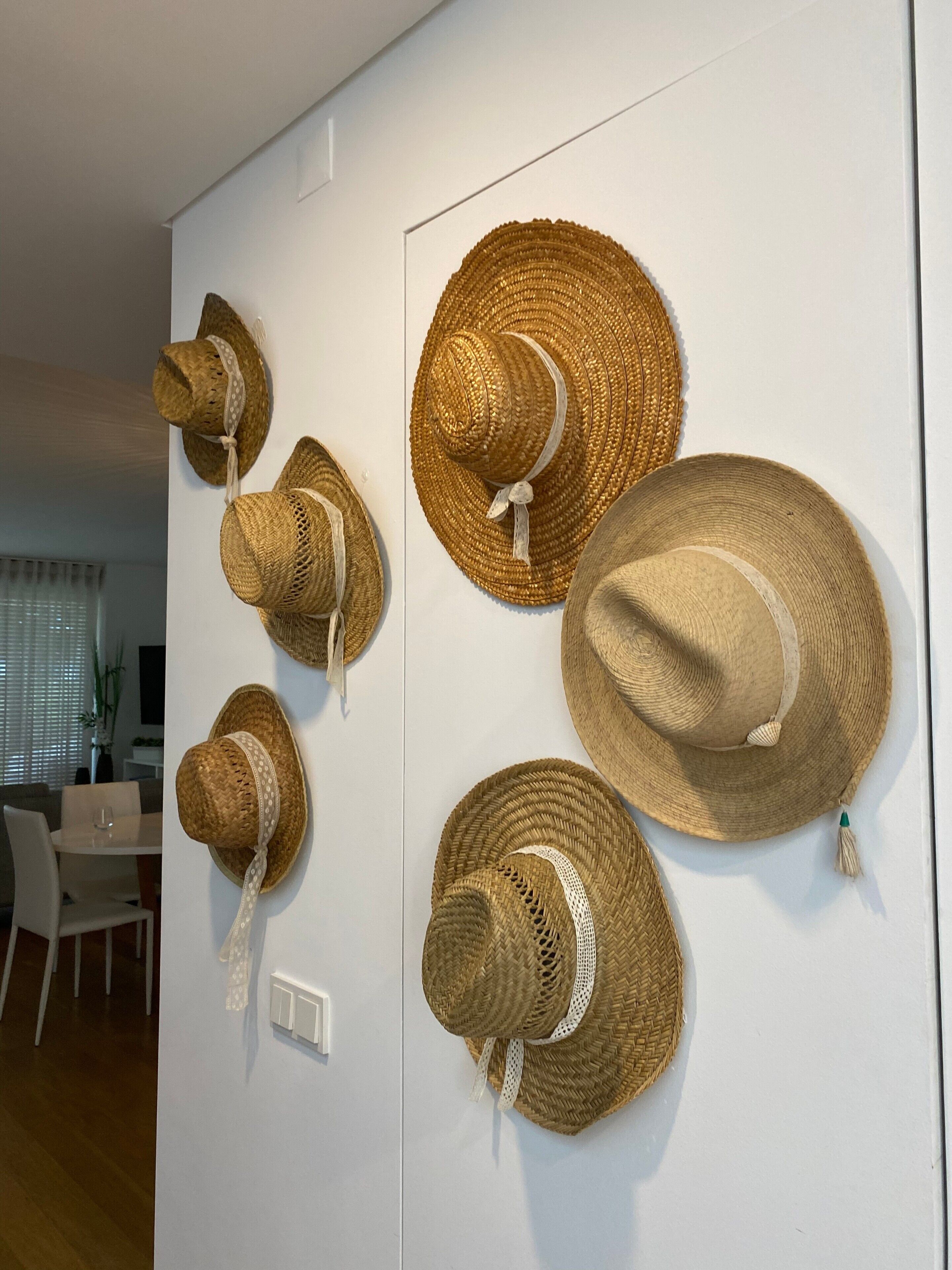 A wall with several woven hats displayed.