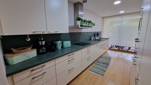 A modern kitchen with a built-in oven, a coffee maker, and a toaster.