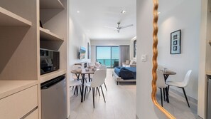 Et moderne hotelværelse med balkon, spiseplads og tekøkken.