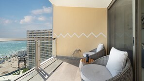 A balcony with a view of the beach, wicker furniture, and a zigzag wall design. - One 1402C Studio: Relaxing Oceanview Studio at Sonoran Star (Puerto Peñasco)